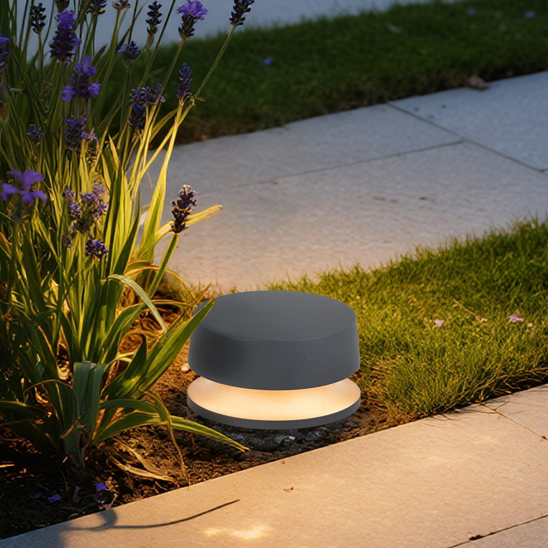 Minimalist LED outdoor landscape lights positioned at the edge of a garden path, enhancing visibility and landscape texture.