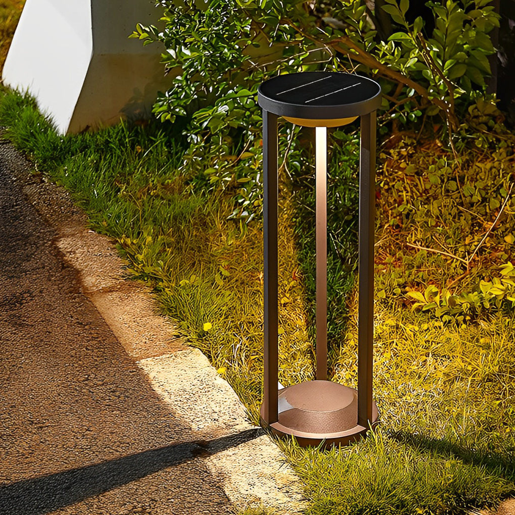 LED solar bollard lights casting a gentle glow near a green hedge.