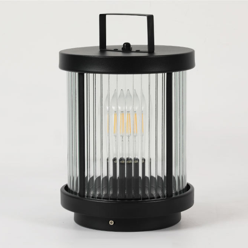 LED solar lantern with a black metal frame, casting a warm glow on an outdoor table setting.