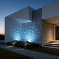 LED wall sconce outdoor exterior spotlights casting blue light patterns on modern building facade at night.