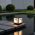 Light box pillar lights illuminating a modern garden pond with bamboo design at night.