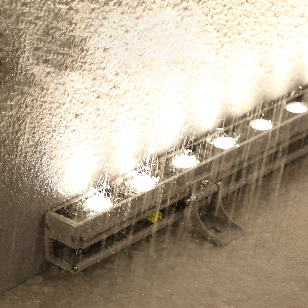 Hand adjusting a linear LED wall washer fixture to highlight its flexibility and installation ease.