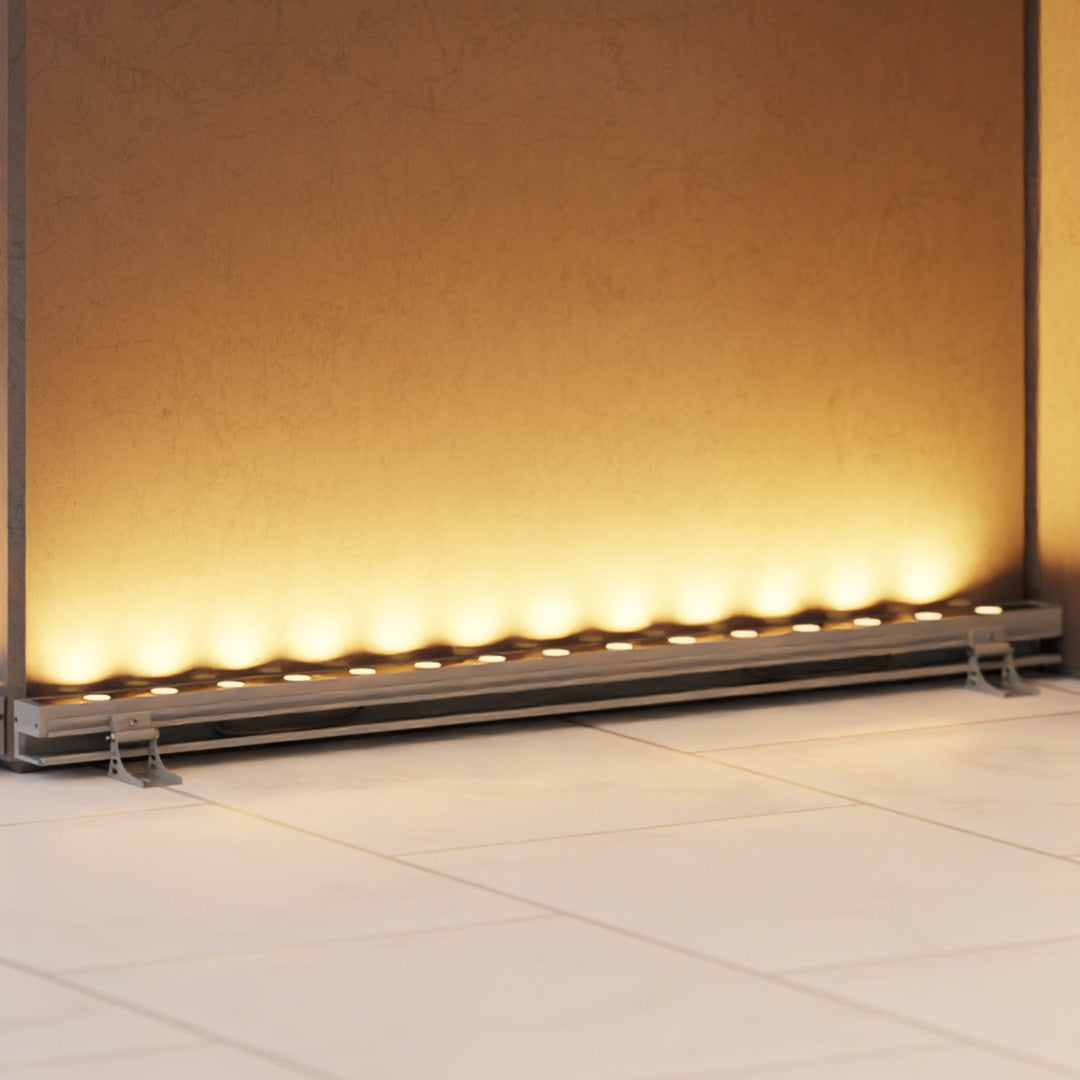 Linear LED wall washer casting a warm golden light on a modern architectural facade at night.