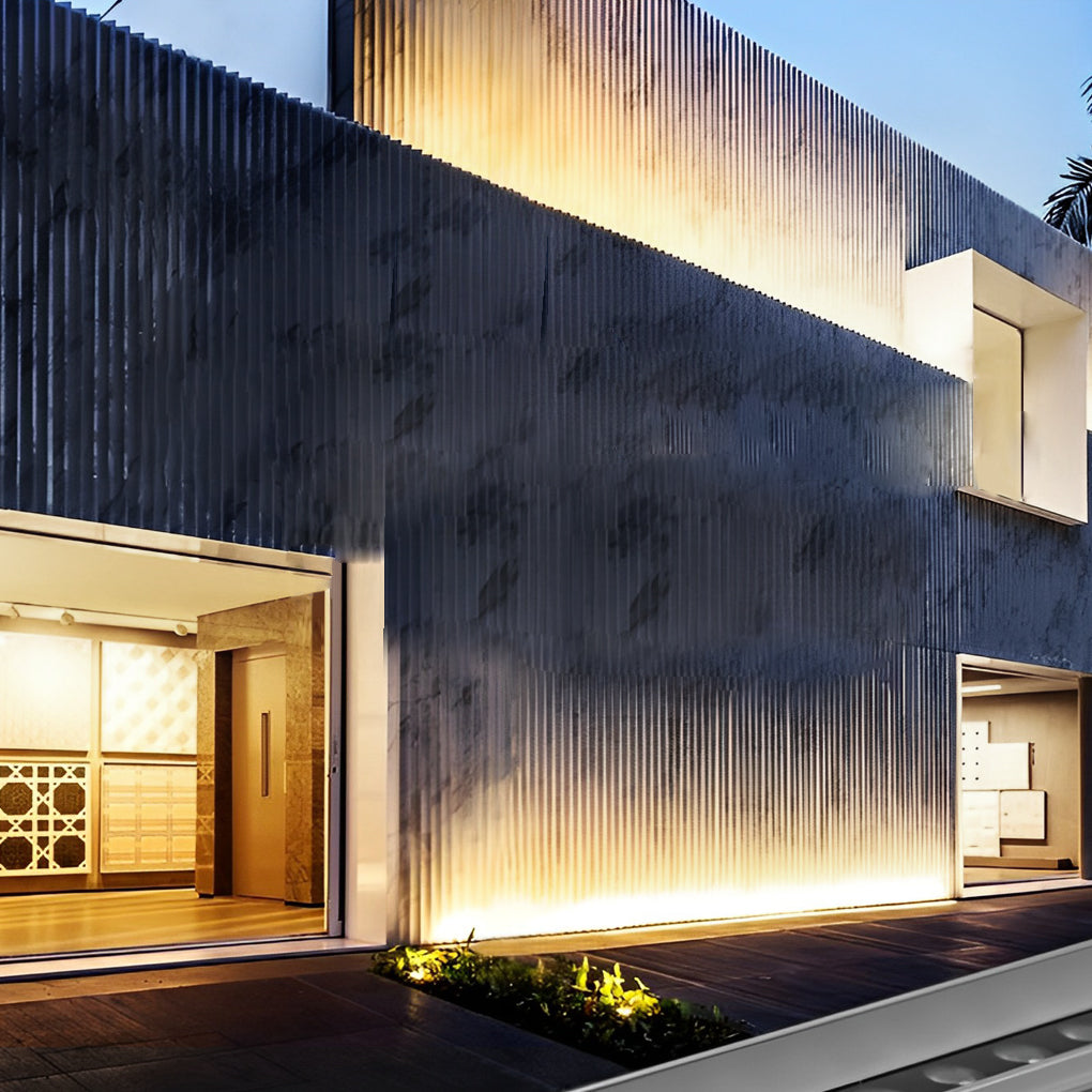 Linear LED wall washer creating a waterfall light effect on a textured outdoor wall surface.