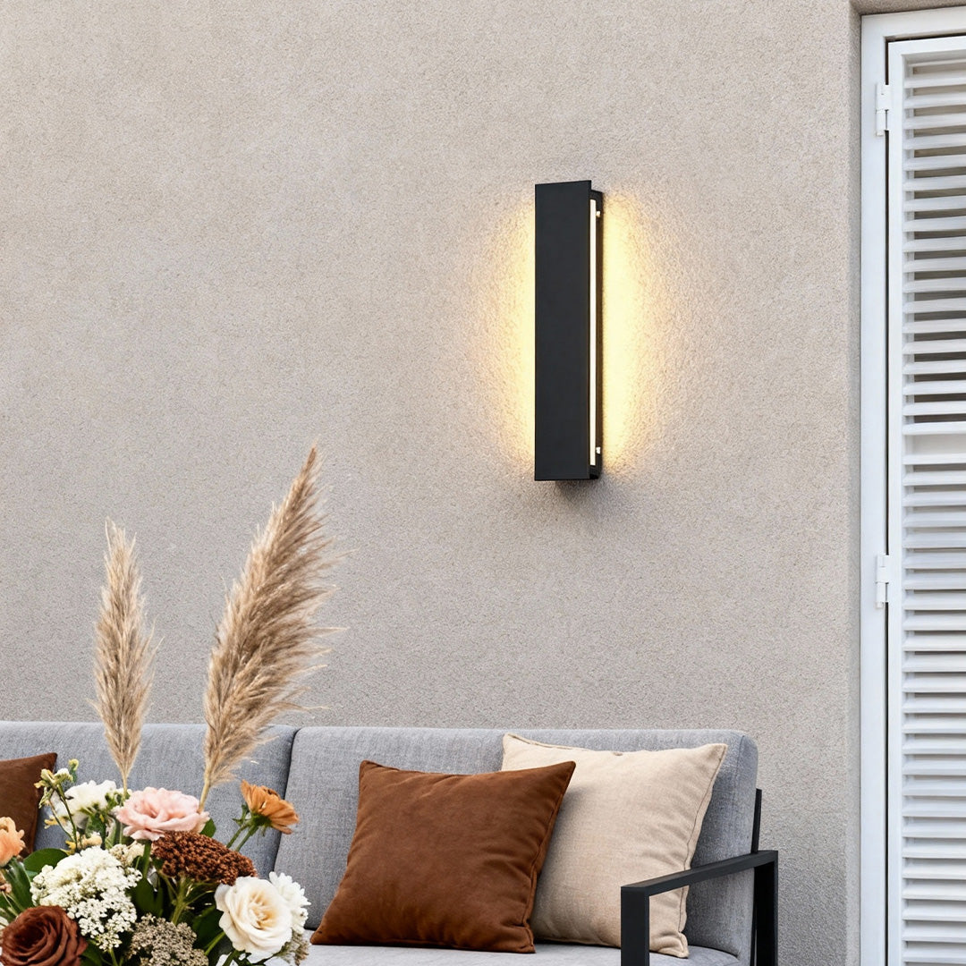 Linear Outdoor Wall Light mounted on a textured exterior wall, featuring a slim black vertical design with warm ambient glow for modern outdoor spaces.