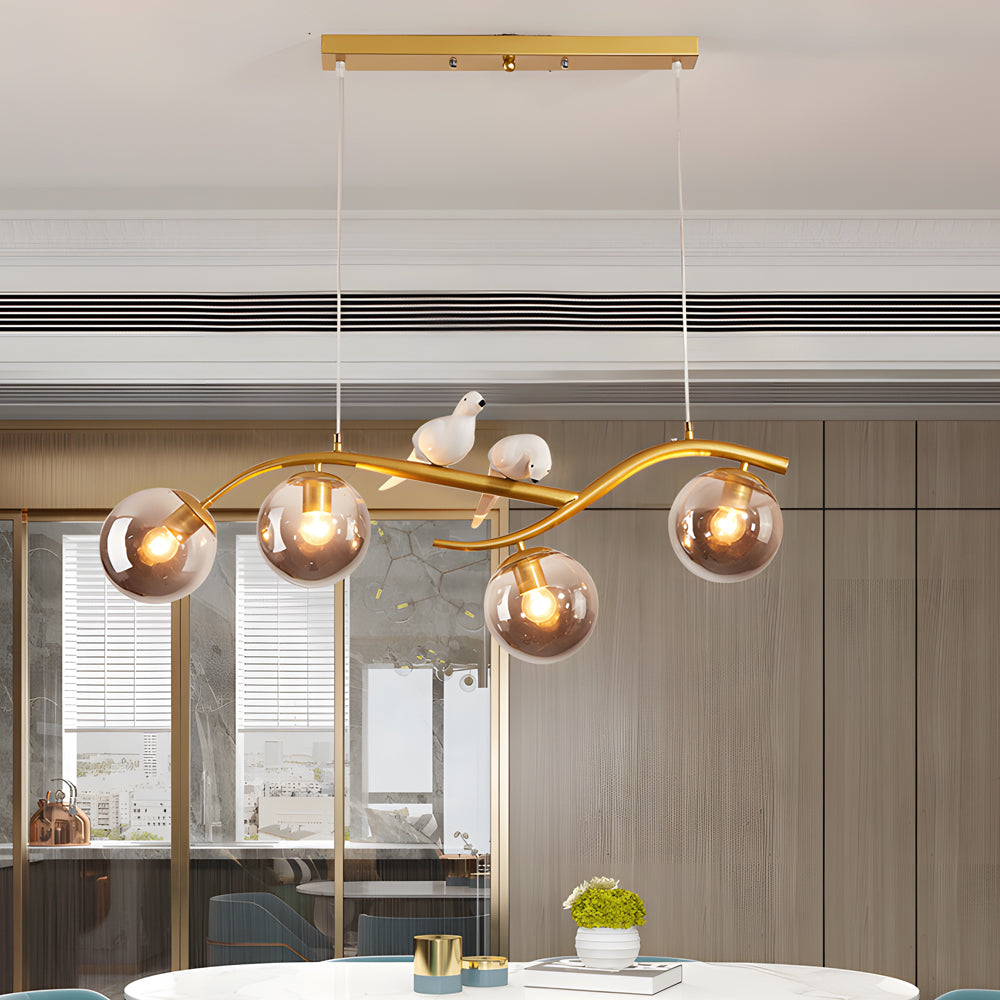 Linear tree branch pendant light with bird details and glass globes.