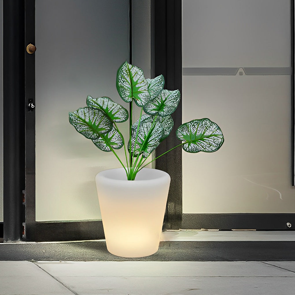 Luminous flower pots glowing softly beside a glass door, enhancing a modern outdoor entrance.
