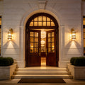 Elegant luxury home entrance illuminated with classic Outdoor Lantern Wall Lights beside an arched wooden doorway.