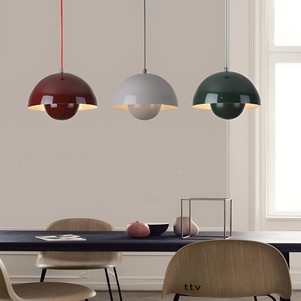 Metal dome pendant light in matte yellow and gray, illuminating minimalist dining area.