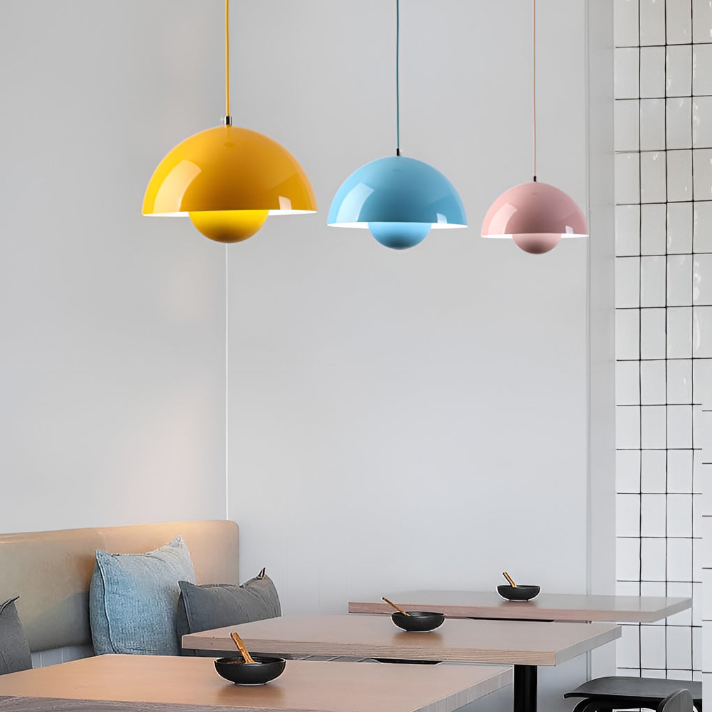 Metal dome pendant light in pastel blue and yellow, hanging above cozy living room sofa.