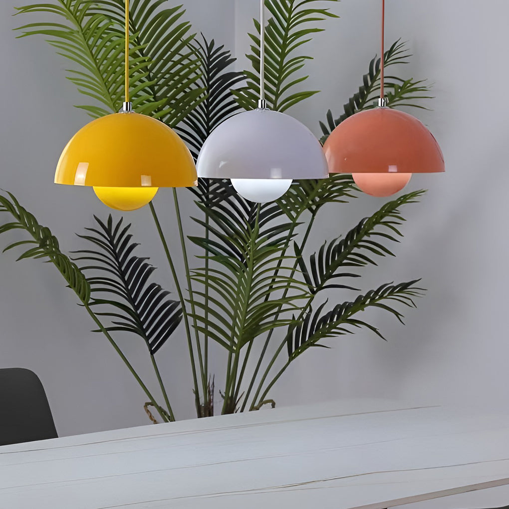 Metal dome pendant light in pastel colors, hanging above indoor plant on modern shelf.