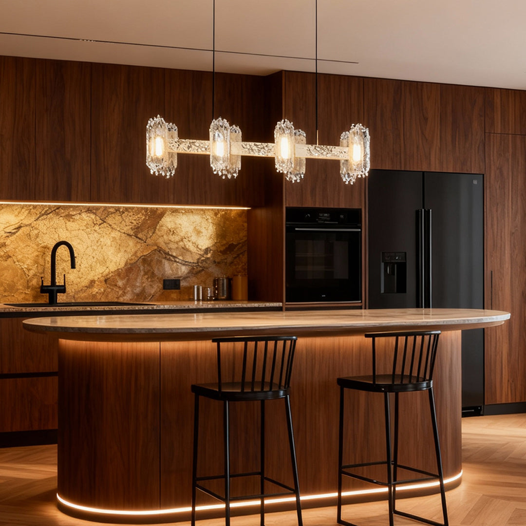 Metal modern chandelier illuminating modern kitchen with rich wood cabinetry and marble backsplash design