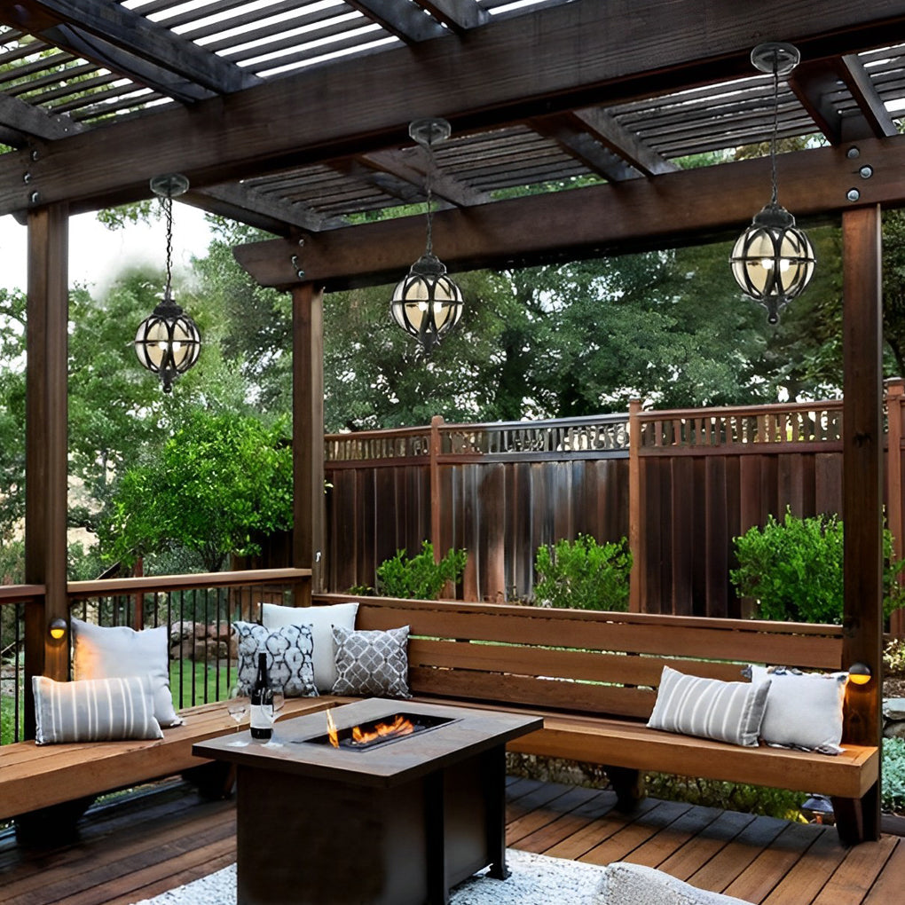 Multiple metal orb pendant lights hanging from a pergola, creating balanced and stylish outdoor lighting design.