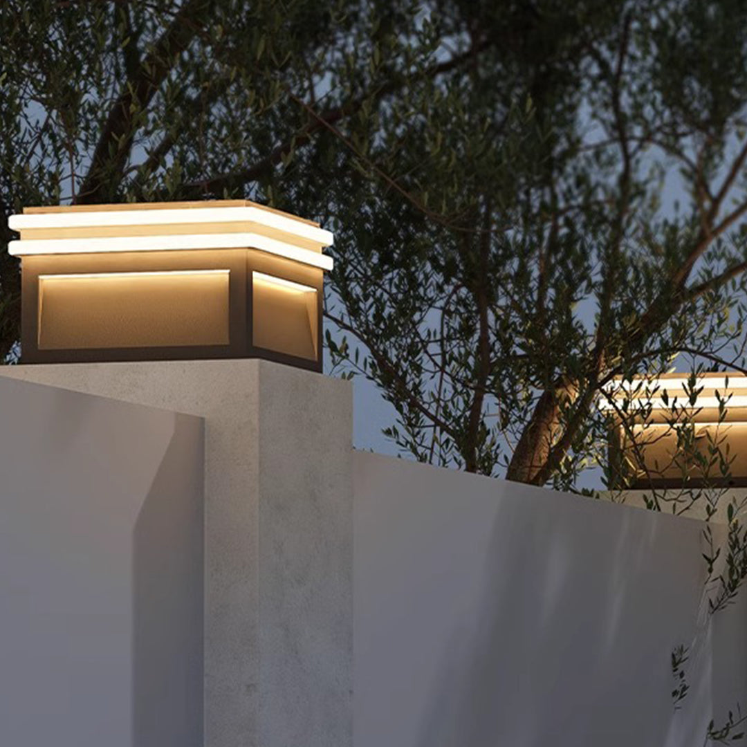 Metal pillar lights illuminating a garden corner, enhancing the landscape with warm light.