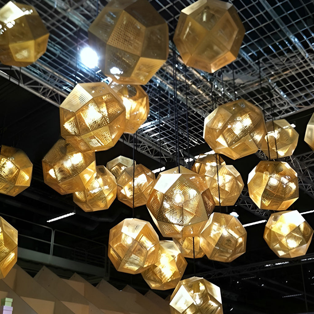 Large group of metal shade pendant light fixtures forming a sculptural chandelier with warm glowing tones.
