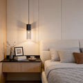 Mini black pendant light hanging beside a modern bedroom bed
