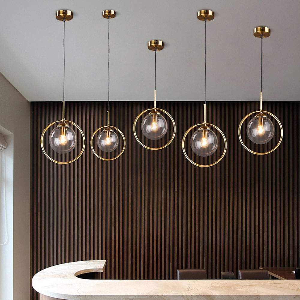 Mini gold pendant light casting a gentle glow in a chic bedroom.
