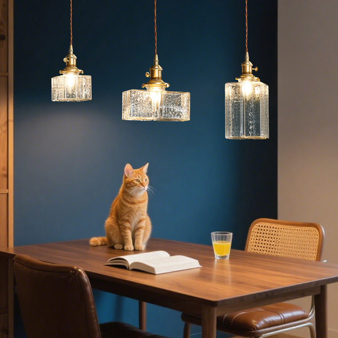 Minimalist square glass pendant light with smooth clear glass and brass hardware for clean modern design.
