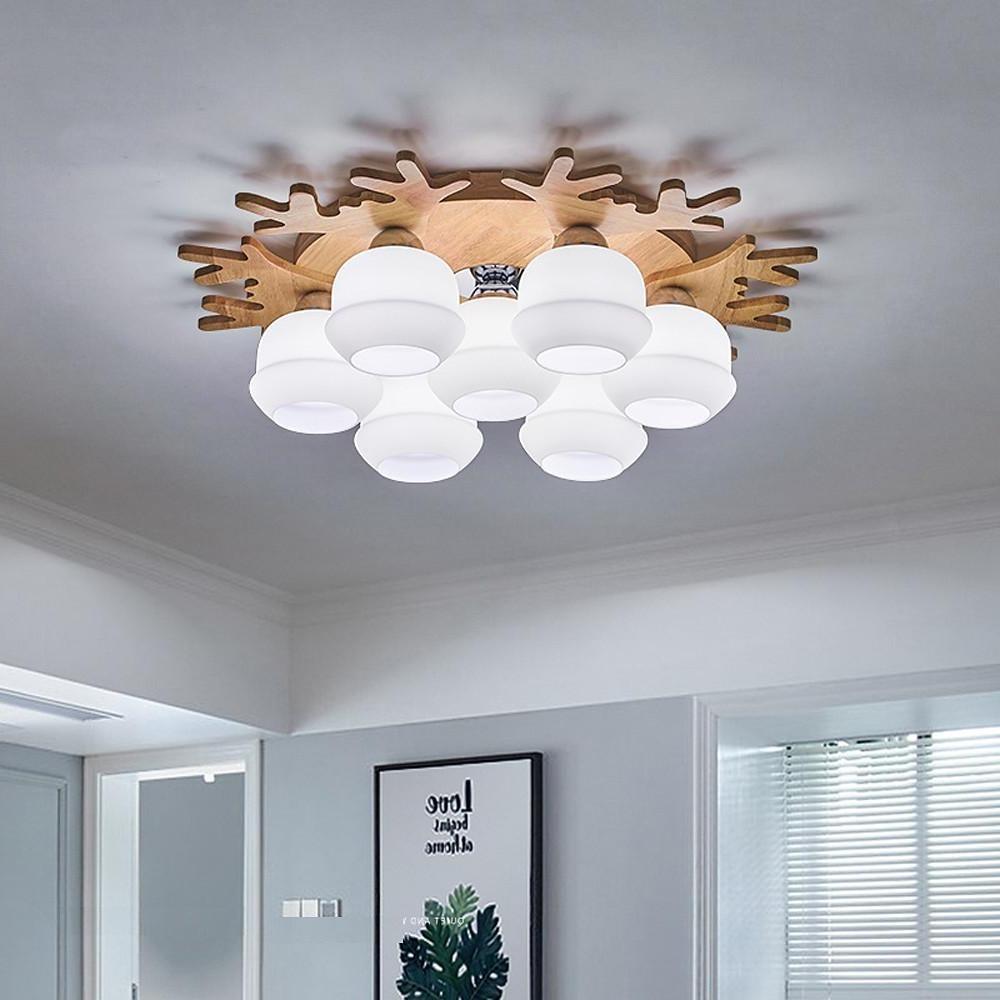 Minimalist white globe ceiling lamp with wooden accents providing soft ambient lighting in a modern bedroom.