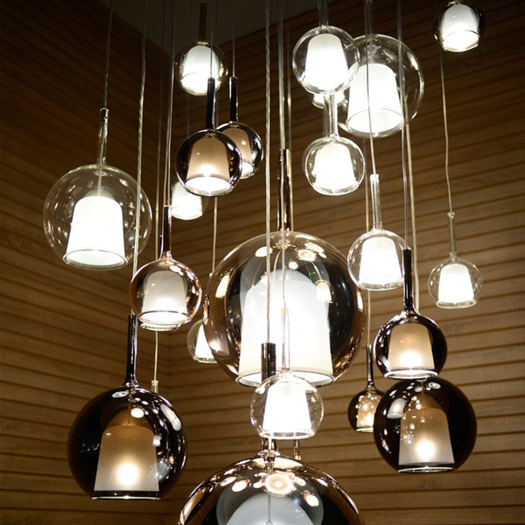 Mixed metal glass ball pendant lights installation over contemporary interior