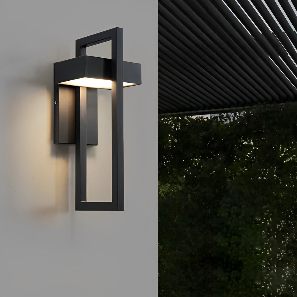 Modern black outdoor wall sconce modern mounted on a white exterior wall near a patio area.