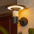 Modern black solar outdoor wall lighting fixture with a bubble glass cylinder and a wide 'halo' shade.