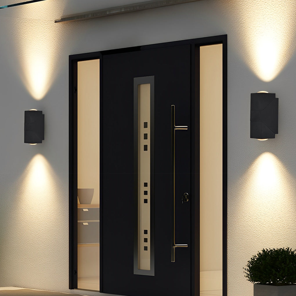 Modern black up down sconce outdoor lighting fixture mounted beside entrance door for stylish exterior illumination.