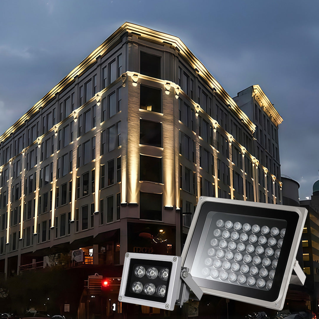 Modern building facade illuminated by vertical uplighting, with two powerful LED architectural flood lights fixtures shown.