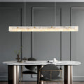 Modern copper metal pendant light with a marble accent, providing stylish illumination in a minimalist kitchen.