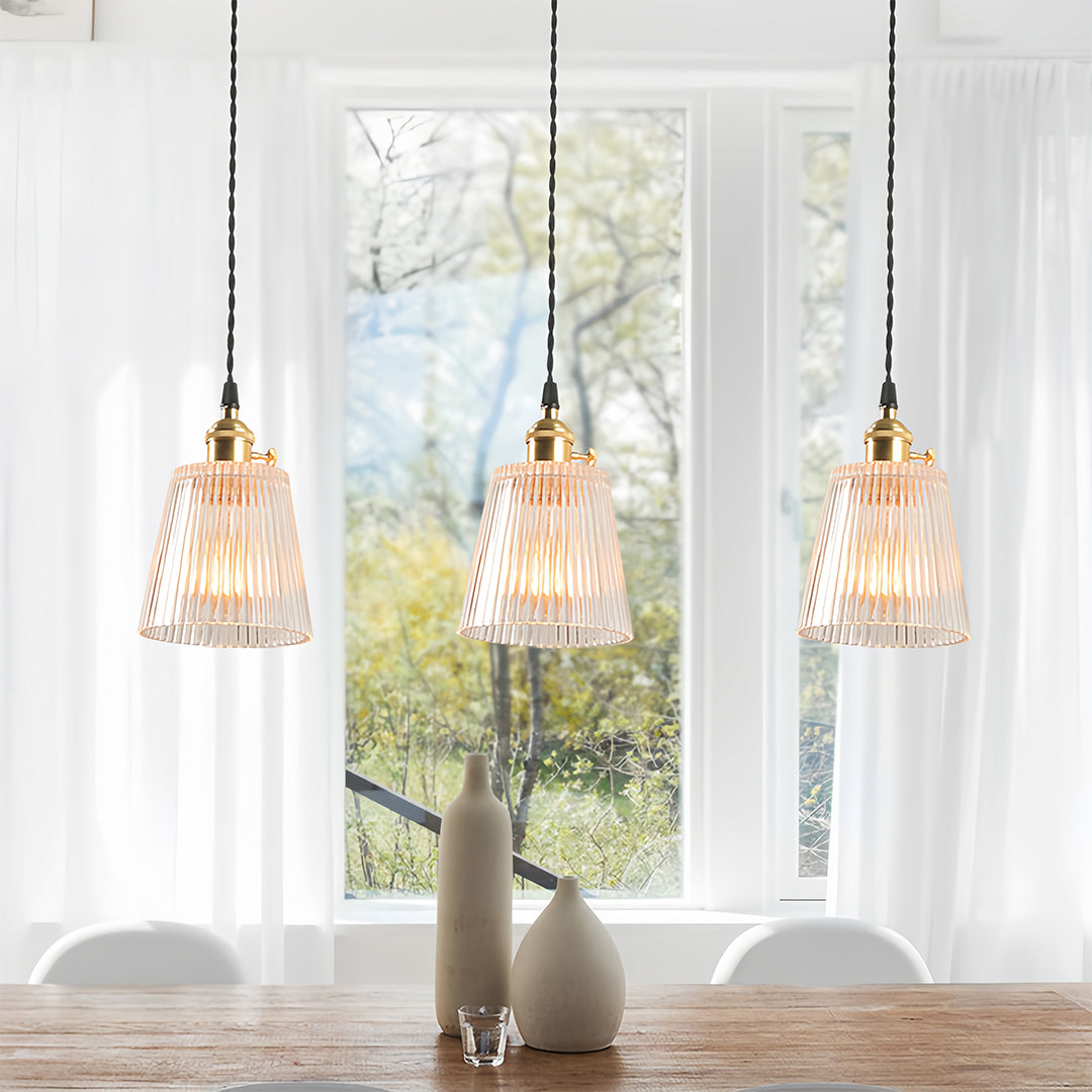 Modern dining room featuring clear glass pendant lights with warm filament bulbs above table