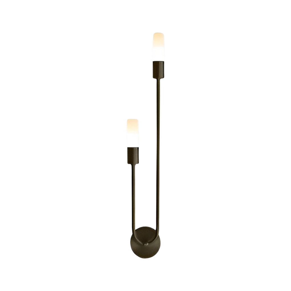 Modern double heads wall sconce with a black and gold finish, providing ambient light near a mirror.