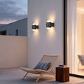 Modern double heads wall sconce illuminating a contemporary house entrance with warm directional light.