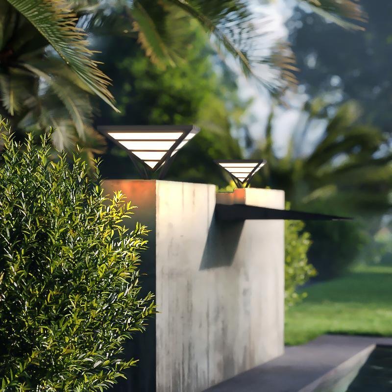 Modern gate pillar light illuminating a garden pathway entrance.