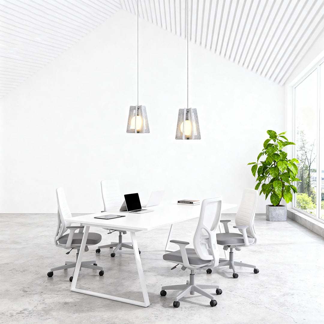 Modern minimalist office featuring geometric fun pendant lights hanging over a long white conference table.