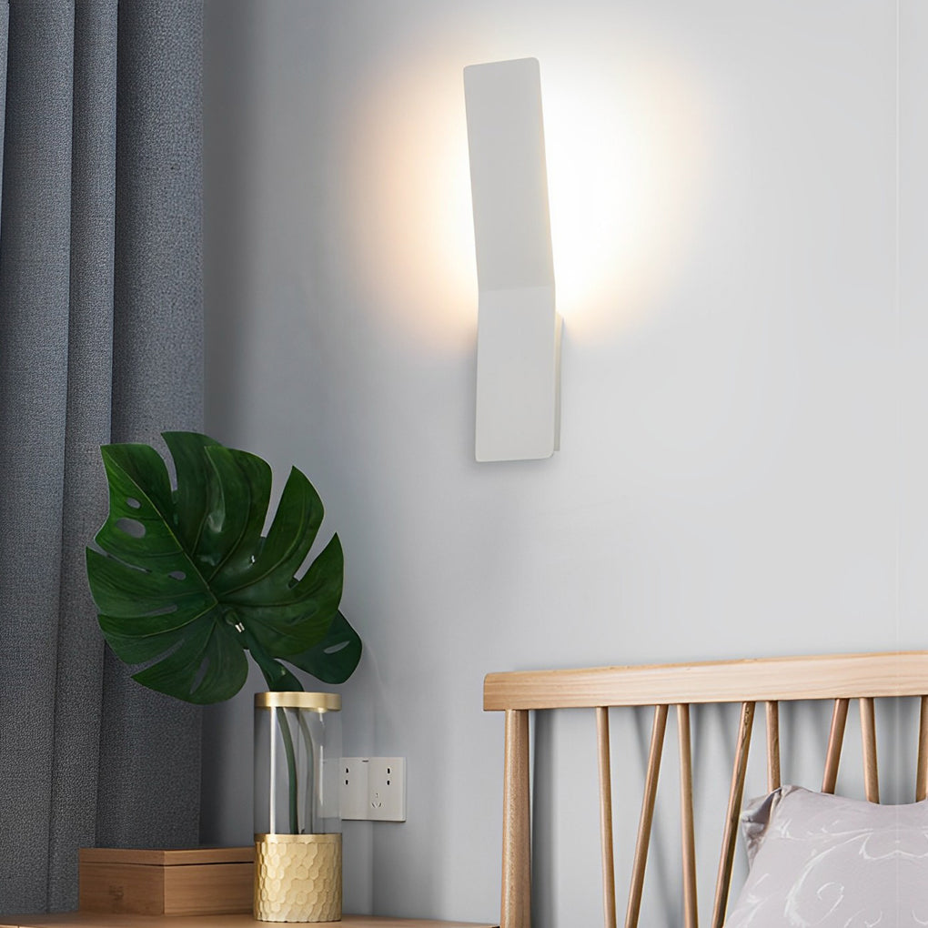 Modern glass pendant chandelier providing warm light beside a wooden headboard.