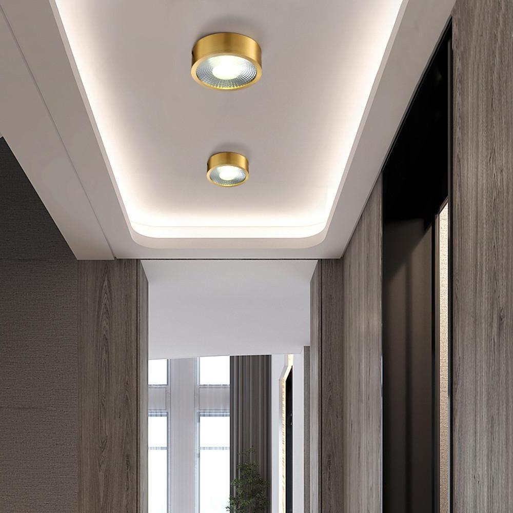 Modern gold downlights recessed into a ceiling with indirect cove lighting.