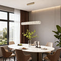 Modern gold pendant light featuring a sleek rectangular frame with crystal accents.