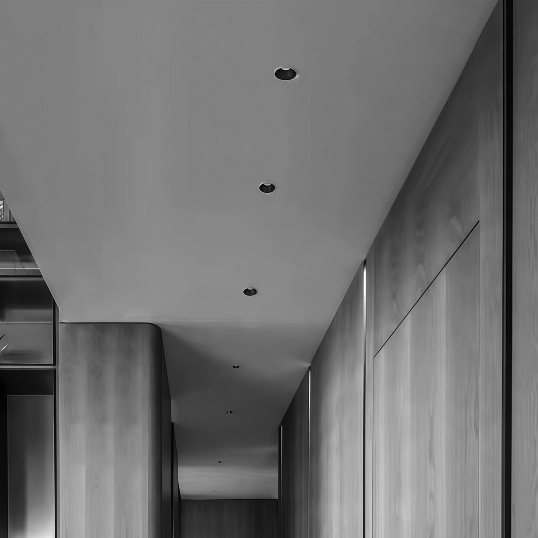 Modern architectural hallway featuring sleek, dark LED downlight recessed fixtures for minimal lighting.