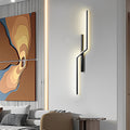 Vertical modern linear wall sconce with sculptural design used as accent lighting in contemporary living room.