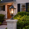Modern main gate pillar light providing soft illumination for a driveway entrance at night.