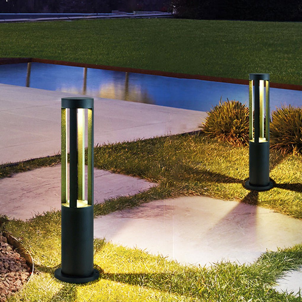 Modern outdoor bollard lights illuminating a garden pathway with a sleek design.