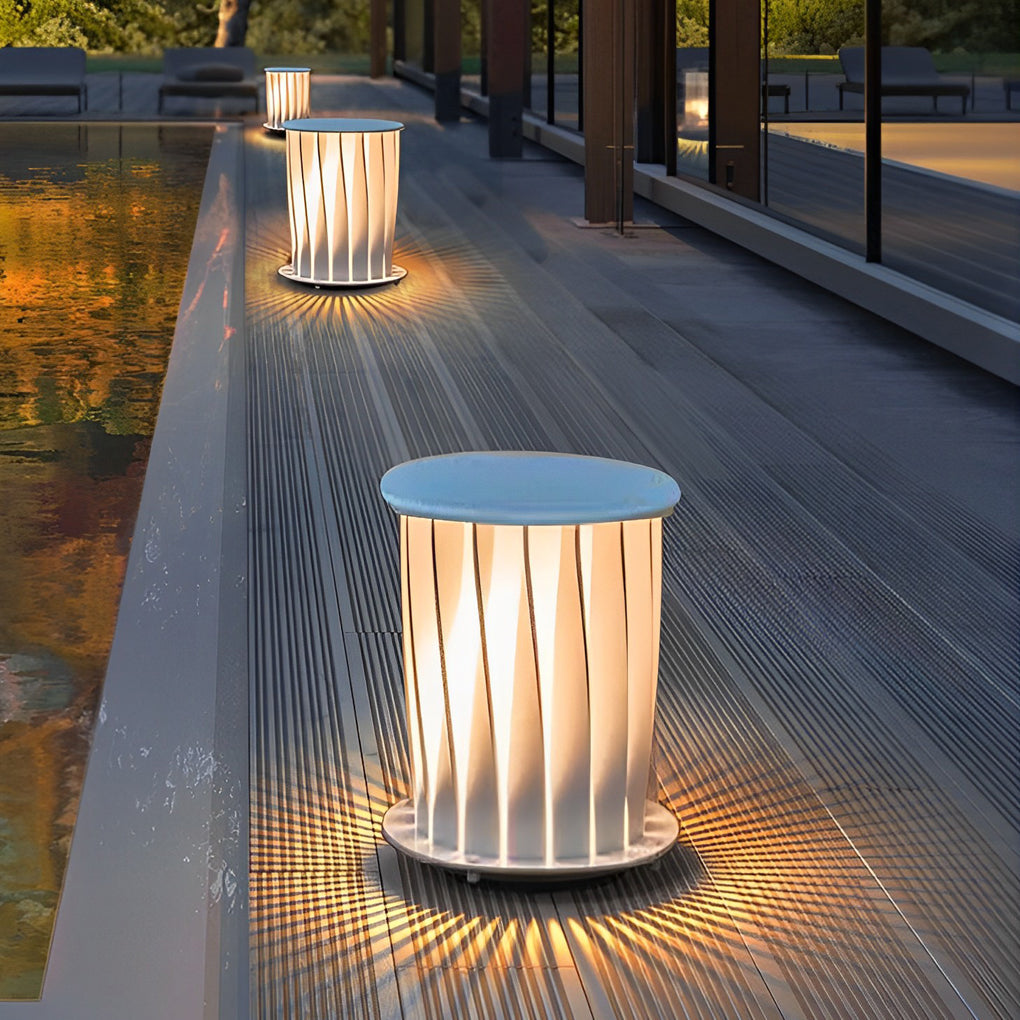 Modern outdoor lanterns installed along wooden deck edge creating warm pathway lighting effect.