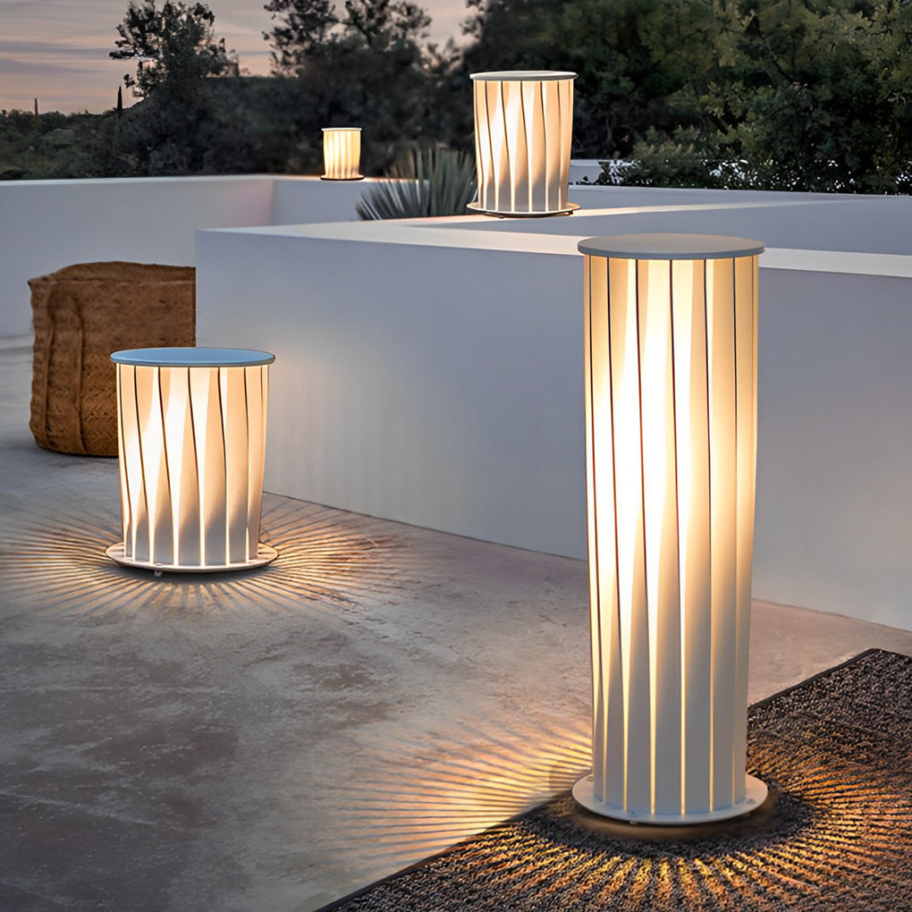 Group of modern outdoor lanterns in different heights creating layered lighting in outdoor space.