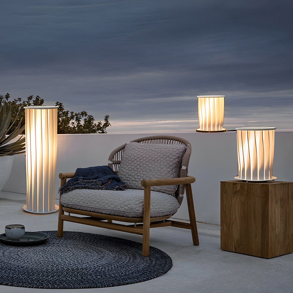 Modern outdoor lanterns used as decorative lighting beside outdoor seating area at dusk.