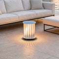 Modern outdoor lanterns casting radial light patterns on patio tiles near a white modern sofa.