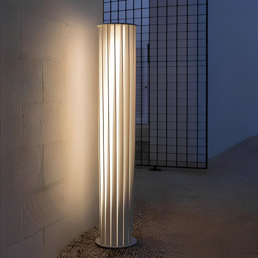 Sleek modern outdoor lanterns positioned against exterior wall with textured surface at night.