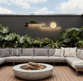 Modern outdoor wall lights with circular LED design mounted on a concrete garden wall daytime.