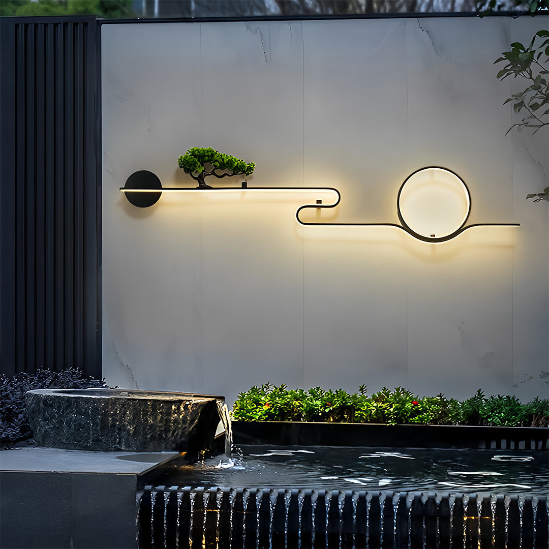 Modern outdoor wall lights with circular LED design mounted on a concrete garden wall at night.
