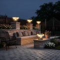 Modern pillar lights for garden illuminating a cozy patio with outdoor furniture and stone walls at dusk.