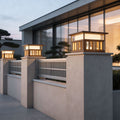 Modern pillar lights for house with a sleek design, installed on a stone fence near a contemporary building.